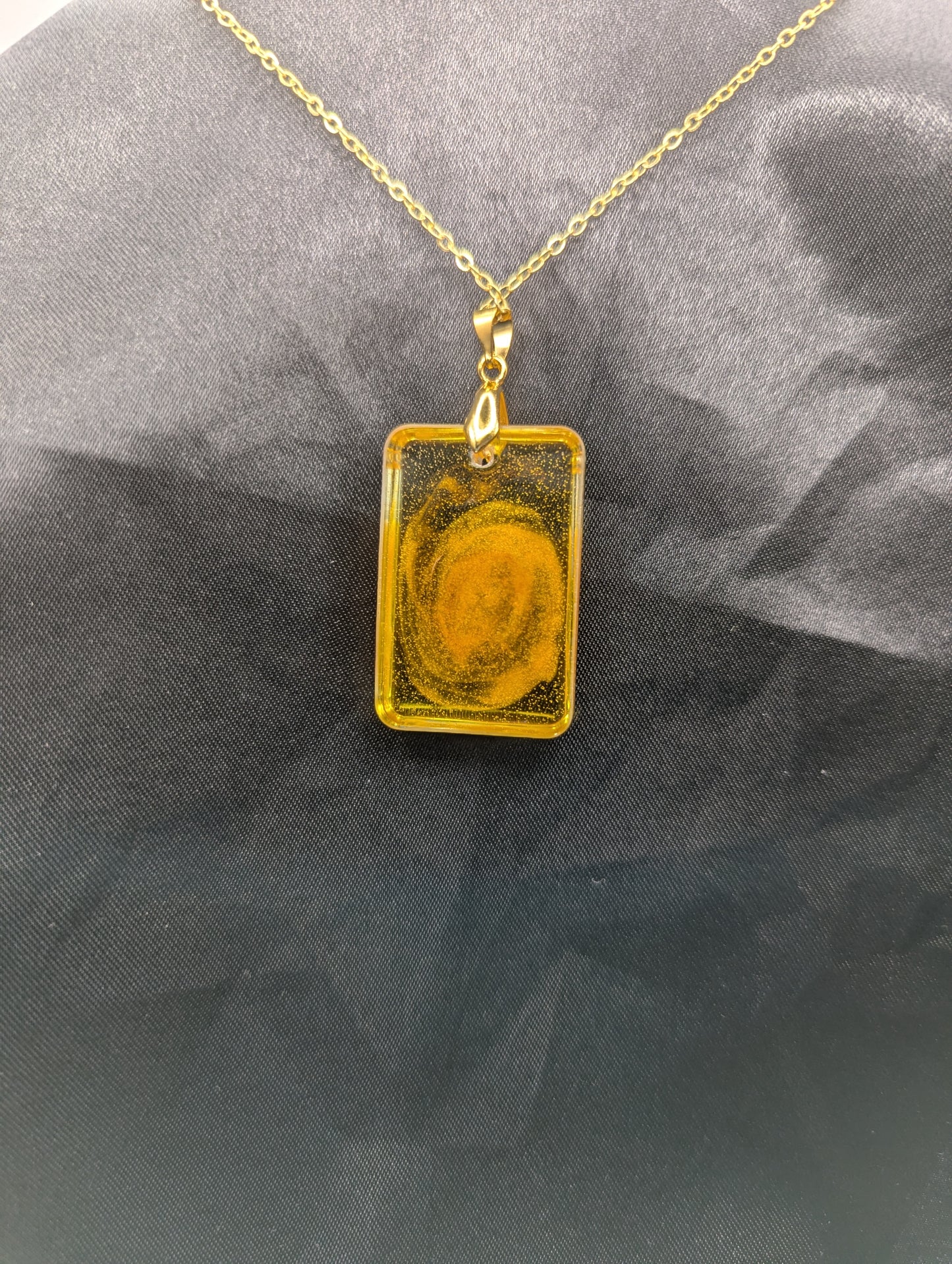 Back view of Yellow & Orange Swirl Rectangle Resin Pendant on a gold pinch bail & gold plated metal chain.
