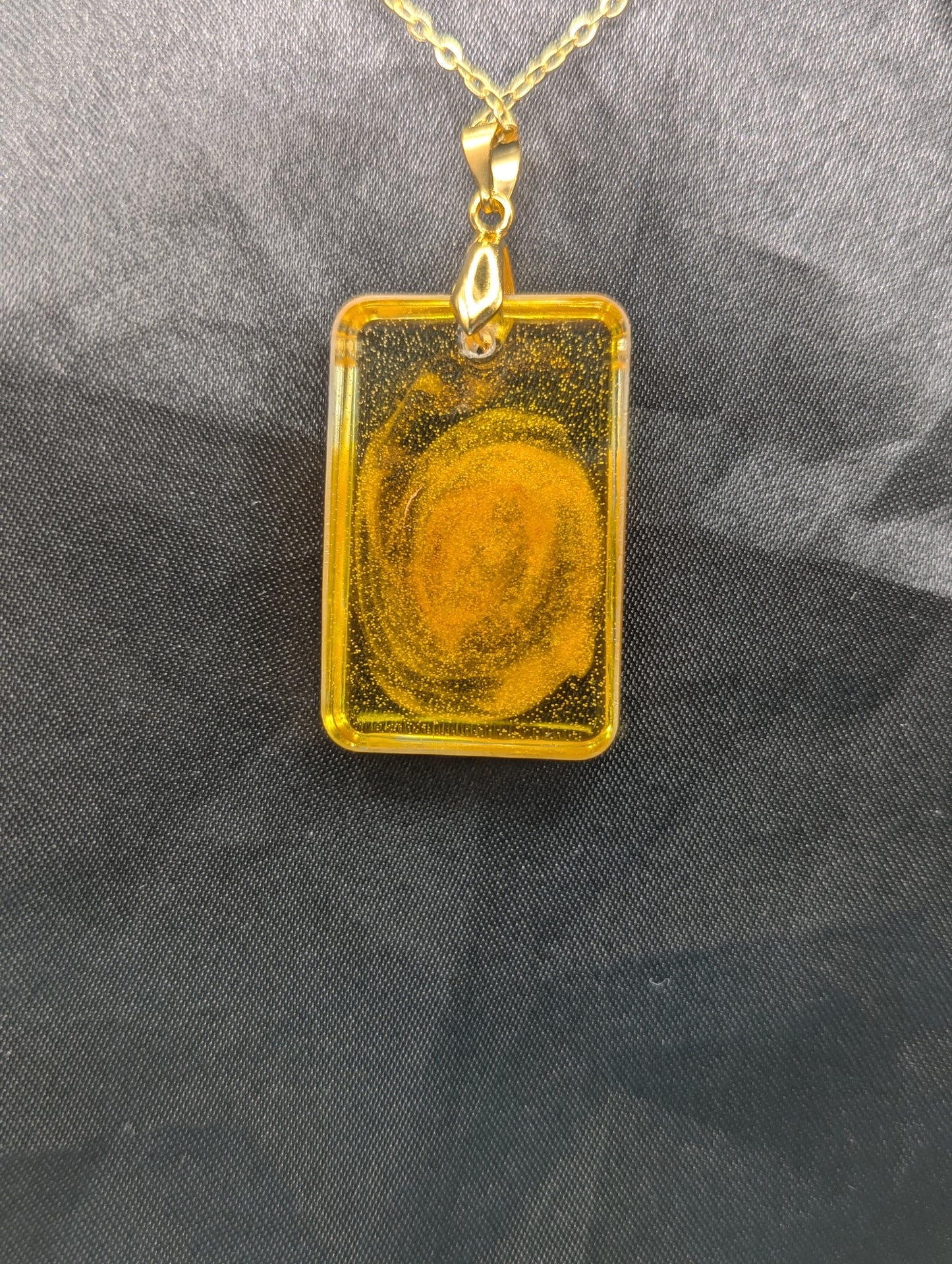 Back view of Yellow & Orange Swirl Rectangle Resin Pendant on a gold pinch bail & gold plated metal chain.