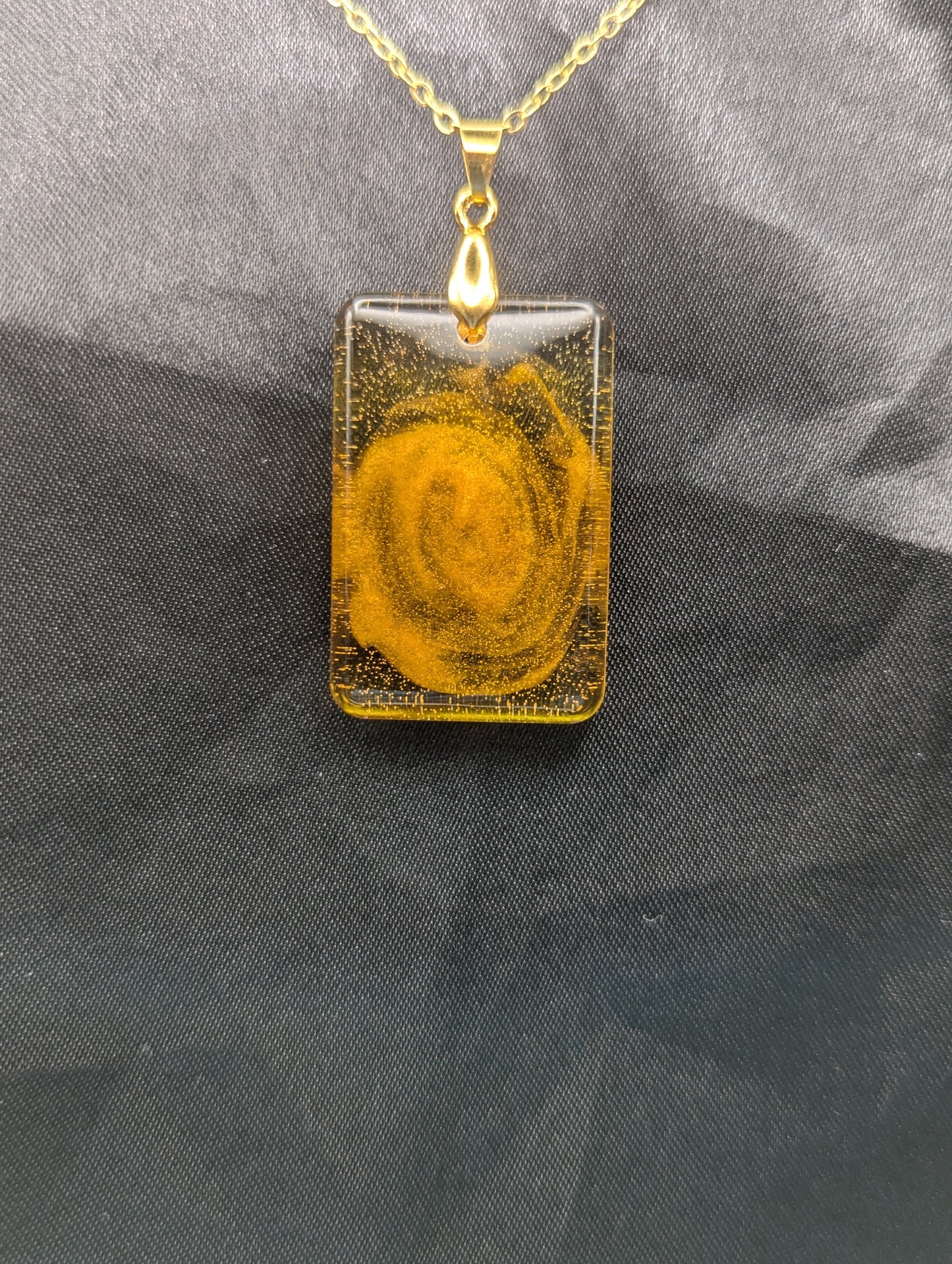 Yellow & Orange Swirl Rectangle Resin Pendant on a gold pinch bail & gold plated metal chain.