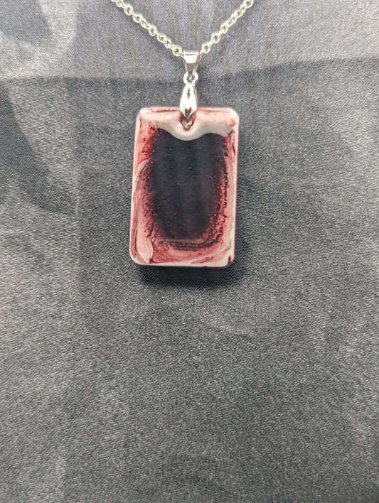 Rectangle resin pendant necklace with dark red swirls and a white background. Resin necklace on a silver pinch bail & stainless steel chain.
