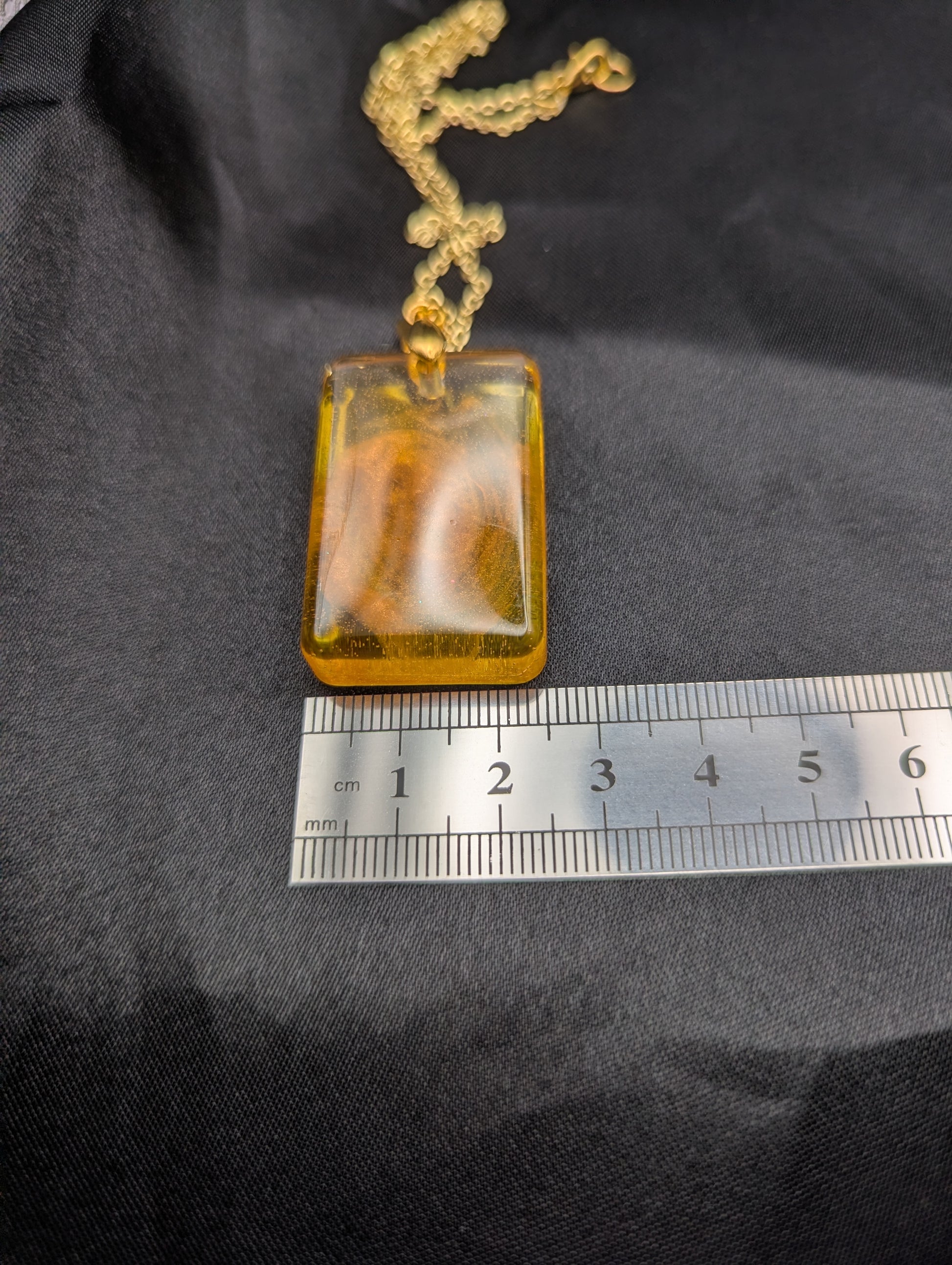 Size example pic of pendant size in centimeters, showing pendant is about 2.5 centimeters wide