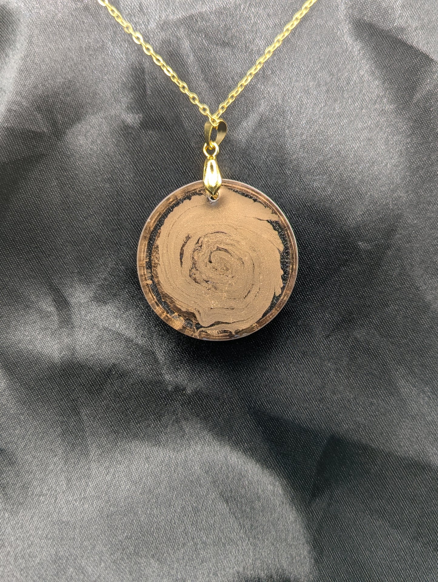 Back view of Rich Gold Swirl Resin Circle Pendant on a gold pinch bail and gold plated metal chain.