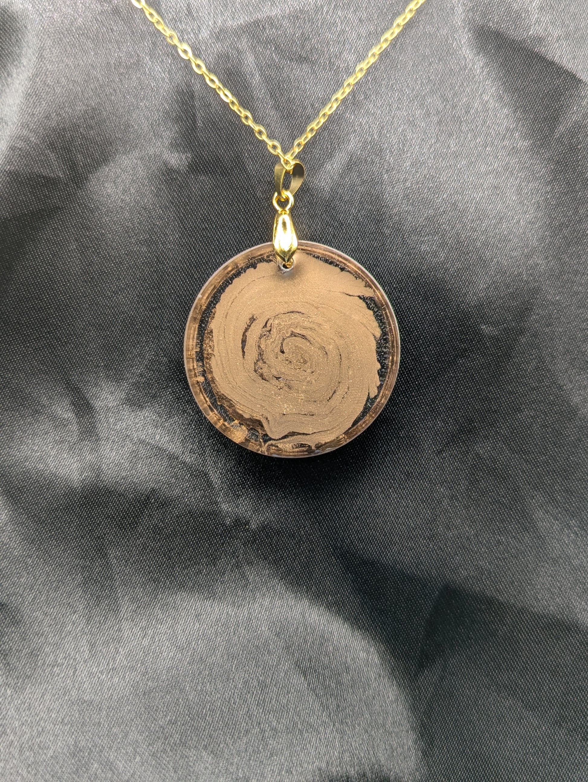 Back view of Rich Gold Swirl Resin Circle Pendant on a gold pinch bail and gold plated metal chain.