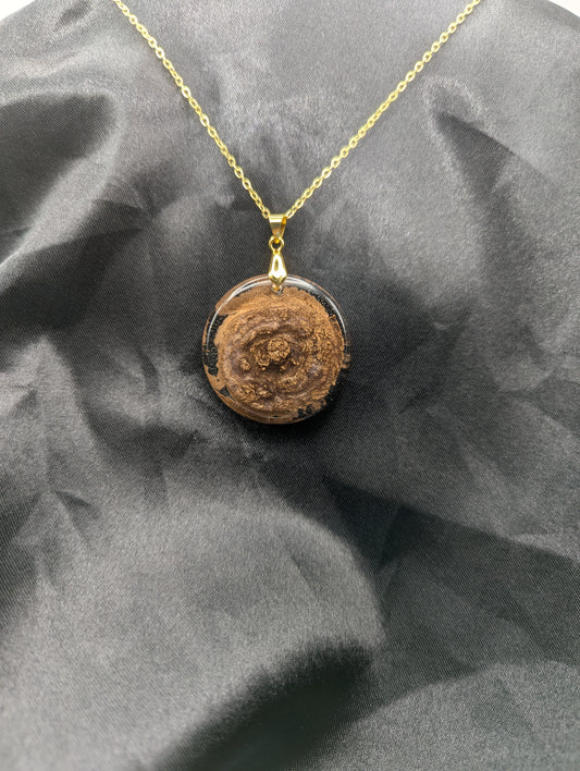 Rich Gold Swirl Resin Circle Pendant on a gold pinch bail and gold plated metal chain.