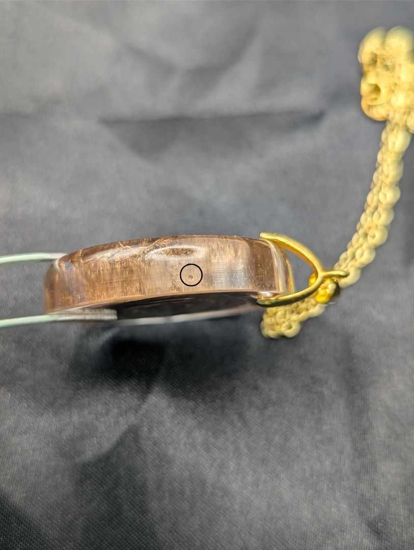 Rich Gold Swirl Resin Circle Pendant on a gold pinch bail and gold plated metal chain.