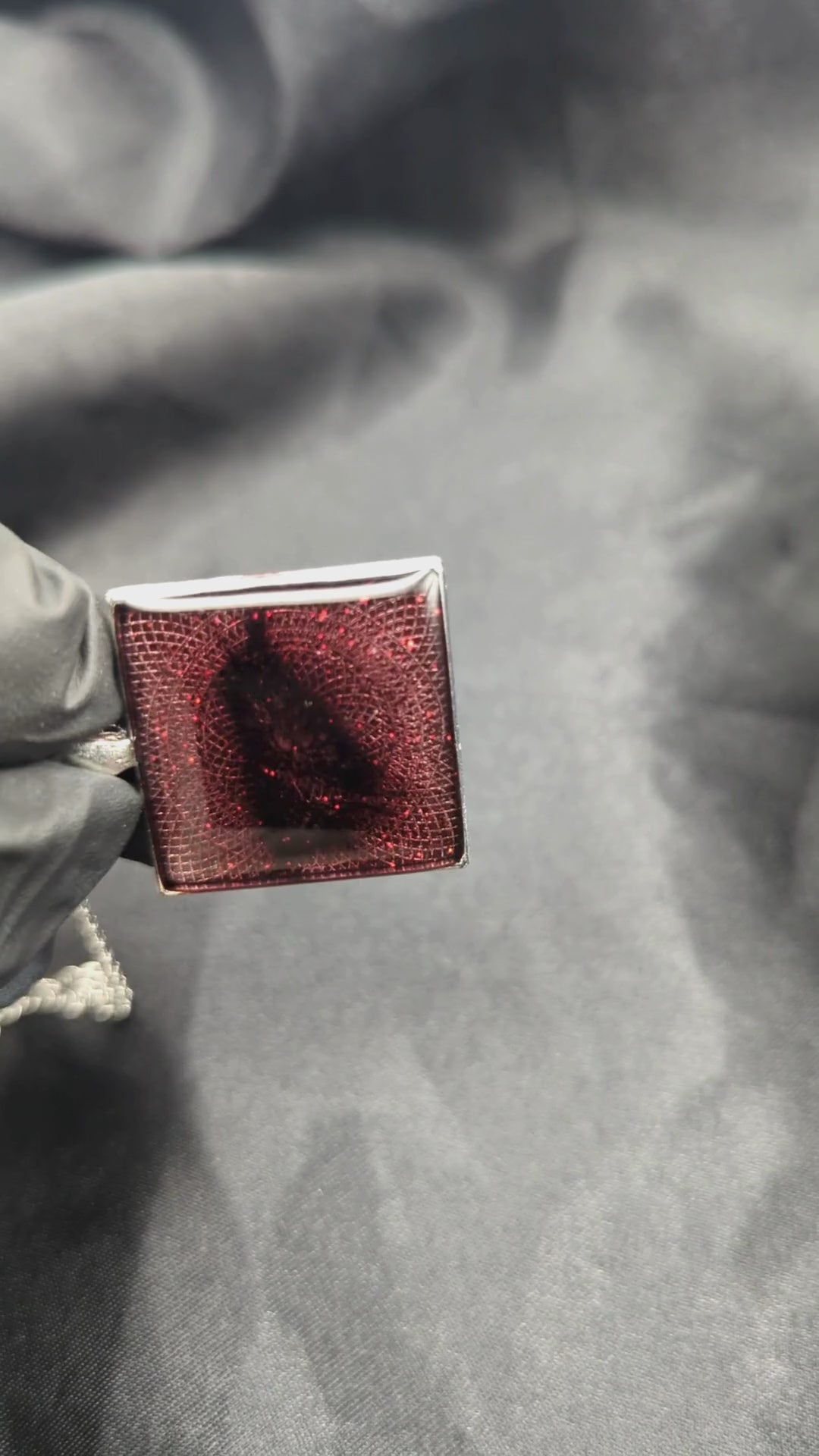 Sparkly maroon colored resin pendant necklace in a square silver bezel.