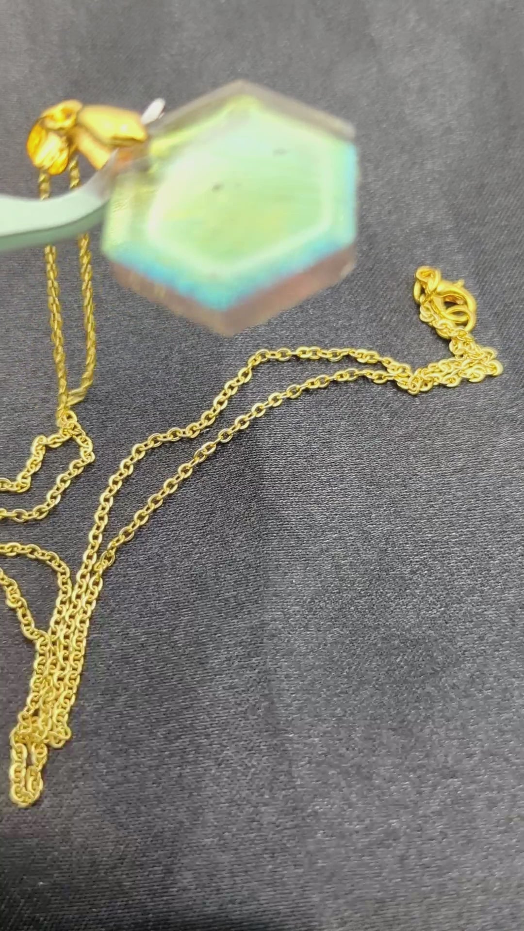 Hexagon shaped resin pendant necklace with color shift pigment on a gold plated metal chain