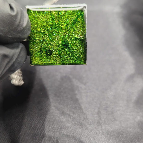 Sparkly green resin pendant necklace in a square bezel on a stainless steel chain